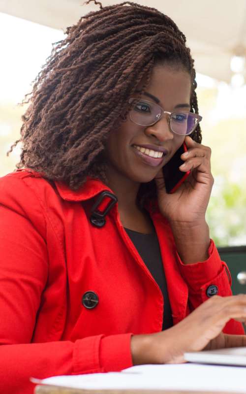 Cheerful woman using laptop and smartphone
